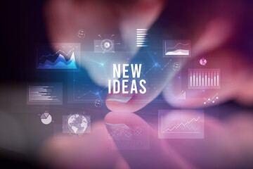 Finger touching tablet with charts and NEW IDEAS inscription, business concept