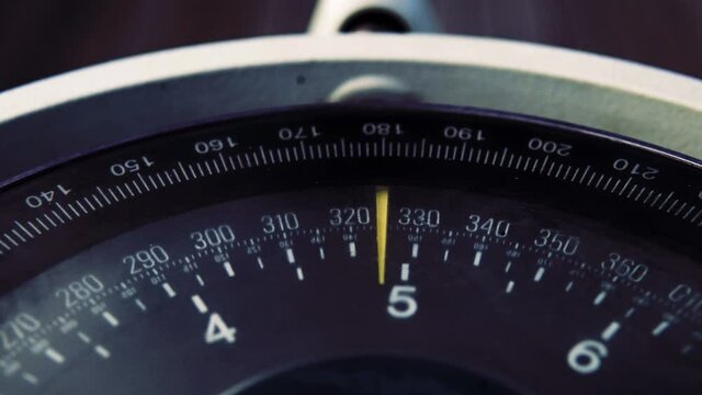 The ship enters the course on the sea compass. The arrow of the sea compass points to the north. The captain chooses the course of the ship on the compass. The device with a black dial and an arrow.