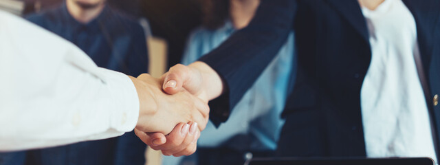 Business people shaking hands in the office. Finished successful partnership, meeting room conference. Wide screen, panoramic © Alex from the Rock