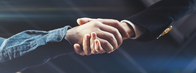 Business people shaking hands in office after successful deal and partnership. Wide screen,...