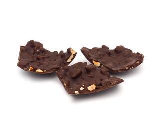 A piece of dark chocolate easter egg with hazelnuts isolated on white background