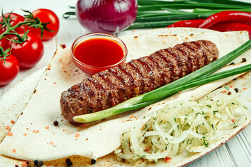 Classical arabic beef or chicken Lula Kebab with onion garnish on wooden board. Appetizing meat on the grill. White background.