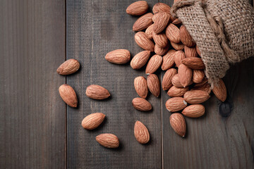 Almonds nuts  peeled in sack on wood table.