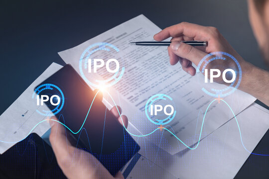 Double exposure of man signing contract with phone and ipo hologram. Concept of initial primary offering, investment.