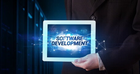 Young business person working on tablet and shows the inscription: SOFTWARE DEVELOPMENT