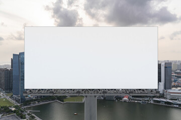 Obraz premium Blank white road billboard with Singapore cityscape background at sunset. Street advertising poster, mock up, 3D rendering. Front view. The concept of marketing communication to sell idea.