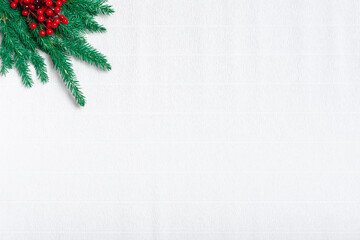 Christmas greeting card. fir branches and Holly berry on white corrugated paper. Space for...