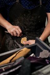 Male cobler sitting at his vintage looking workshop and cutting leather fabric for shoe repairing