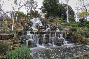 Fototapeta na wymiar waterfall in the park, long exposure, stones and trees 