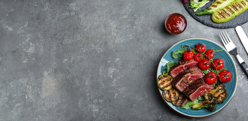 Flat lay composition with delicious sliced beef steak on grey table, space for text. Banner design
