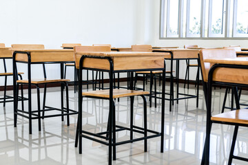 Lecture room, School empty classroom with desk chair iron wood for studying lessons in high school. No student in situation of Covid-19 disease outbreak result in inability organize teaching learning
