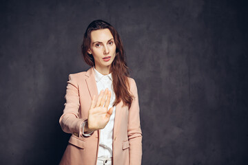 caucasian woman show stop sign on dark background