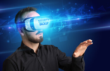 Businessman looking through Virtual Reality glasses with SECURITY BACKUP inscription, cyber security concept
