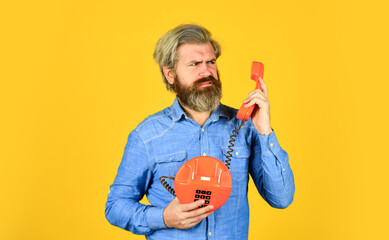 Man with moustache holding vintage phone. vintage communication device. Businessman talking on...