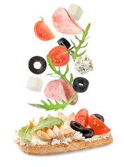 Tasty bruschetta with flying ingredients on white background