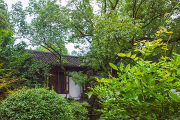 House among trees in Chinese garden in West Lake scenic area in Hangzhou, China
