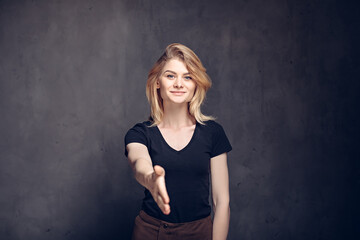 Fototapeta na wymiar caucasian girl shaking hand on dark background