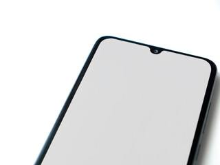 Black mobile smartphone mockup lies on the surface with blank screen isolated on white background