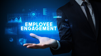 Hand of Businessman holding EMPLOYEE ENGAGEMENT inscription, business success concept
