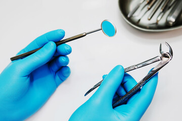 Dentist doctor's hands with tools on white background