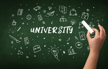 Hand drawing UNIVERSITY inscription with white chalk on blackboard, education concept