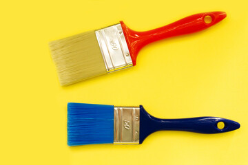 Samples of paint brushes. Multi-colored brushes on a yellow background