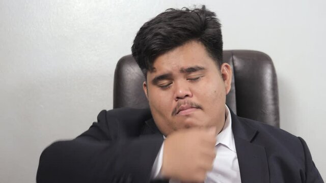 A funny Asian fat businessman wearing a suit look like the head of corporate executive or business manager feel very sad to cry because he failed to do business.