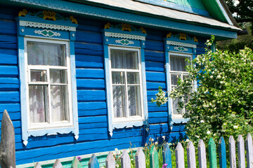 Fototapeta na wymiar Ornamental carved windows and frames. Vintage rural house in Belarus. Traditional national folk style in wooden architecture.