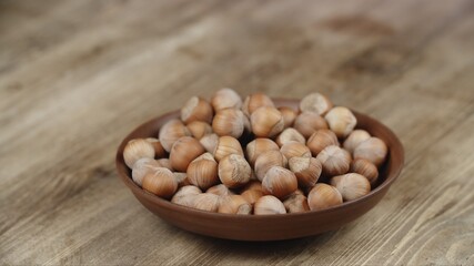 Bowl with Hazelnut on wooden table