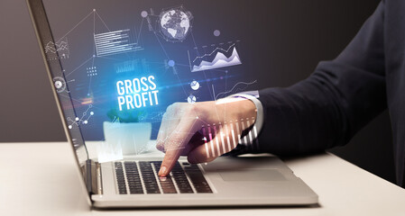Businessman working on laptop with GROSS PROFIT inscription, new business concept