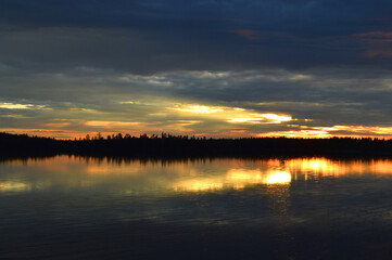 Obraz premium Finnish summer night. Lake and sunset. Fading light, strong colors. Blue and yellow.
