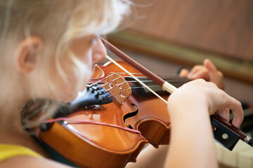 little girl with concentration playing a small violin, suzuki lessons, horizontal shape, music...