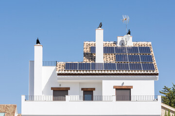 A white house with solar panels on the roof on a sunny summer morning in Andalusia
