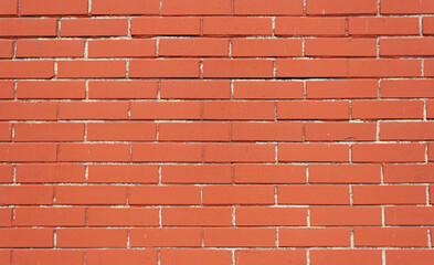 Obraz premium Background of red brick texture. Brown brick wall with uneven seam. Building pattern. The construction of a stone wall. Old concrete fence with a shadow from the sun. Design.