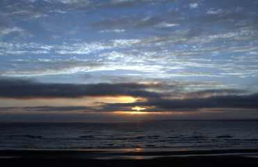 Beach scene beautiful sunset and dynamic clouds over Pacific Ocean