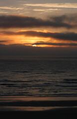 Fototapeta na wymiar Beach scene beautiful sunset and dynamic clouds over Pacific Ocean