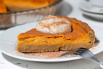 piece of pumpkin pie with cream, closeup