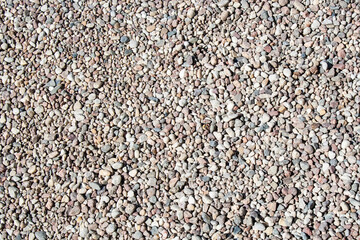 Gravel texture Small stones, little rocks, pebbles in many shades of grey, white, brown, pink colour in close-up. Crushed granite texture. Road made of stones from river or lake Small rock background