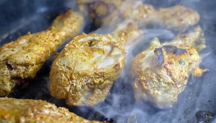 Obraz premium Smokey Chicken tangdi or Tangri kebab or kabab being cooked in a grill pan