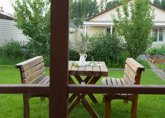 Recreation area on the garden site. A wooden table and wooden benches on a green lawn. It's a dump. Garden furniture