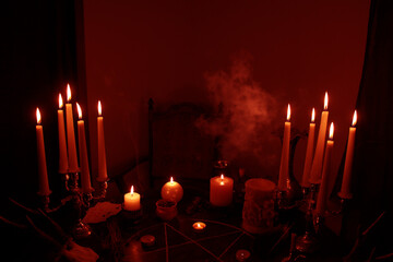 in a dark room on a round esoteric table candles burn, smoke, animal skulls lie, a pentagram is...