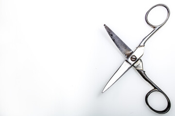 open metal scissors, silver in color, placed on a white surface