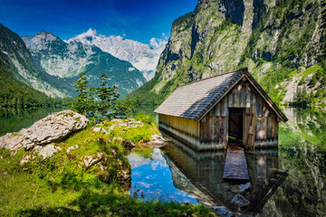 Fototapeta na wymiar Beautiful house at the lake Obersee and green mountains in bavaria, germany in the summer.
