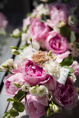 wedding attribute made of fabric lies on peonies, bouquets of pink flowers on background