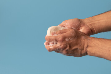 Washing hands with soap isolated on blue background.