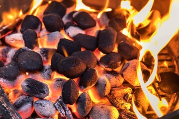 Top View Of Hot Flaming Charcoal Briquettes Glowing In The BBQ Grill Pit. Grill briquettes that are...
