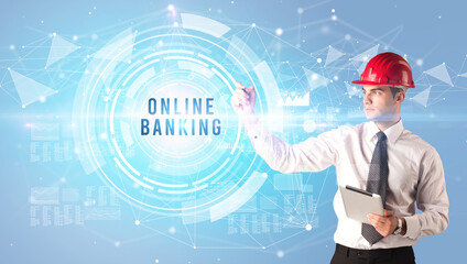 Handsome businessman with helmet drawing ONLINE BANKING inscription, contruction business concept