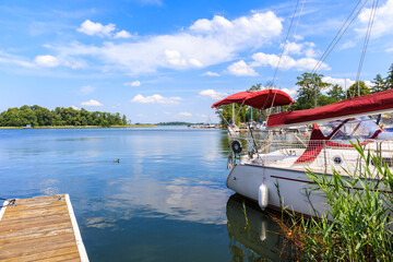 Sailing boat anchoring at shore of Lake Beldany in port Wierzba on summer sunny day, Mazury Lake District, Poland © pkazmierczak