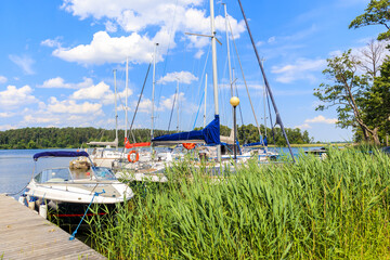Sailing boats anchoring at shore of Lake Beldany in port Wierzba on summer sunny day, Mazury Lake District, Poland © pkazmierczak