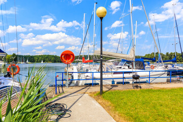 Sailing boats anchoring at pier on Lake Beldany in port Wierzba on summer sunny day, Mazury Lake District, Poland © pkazmierczak